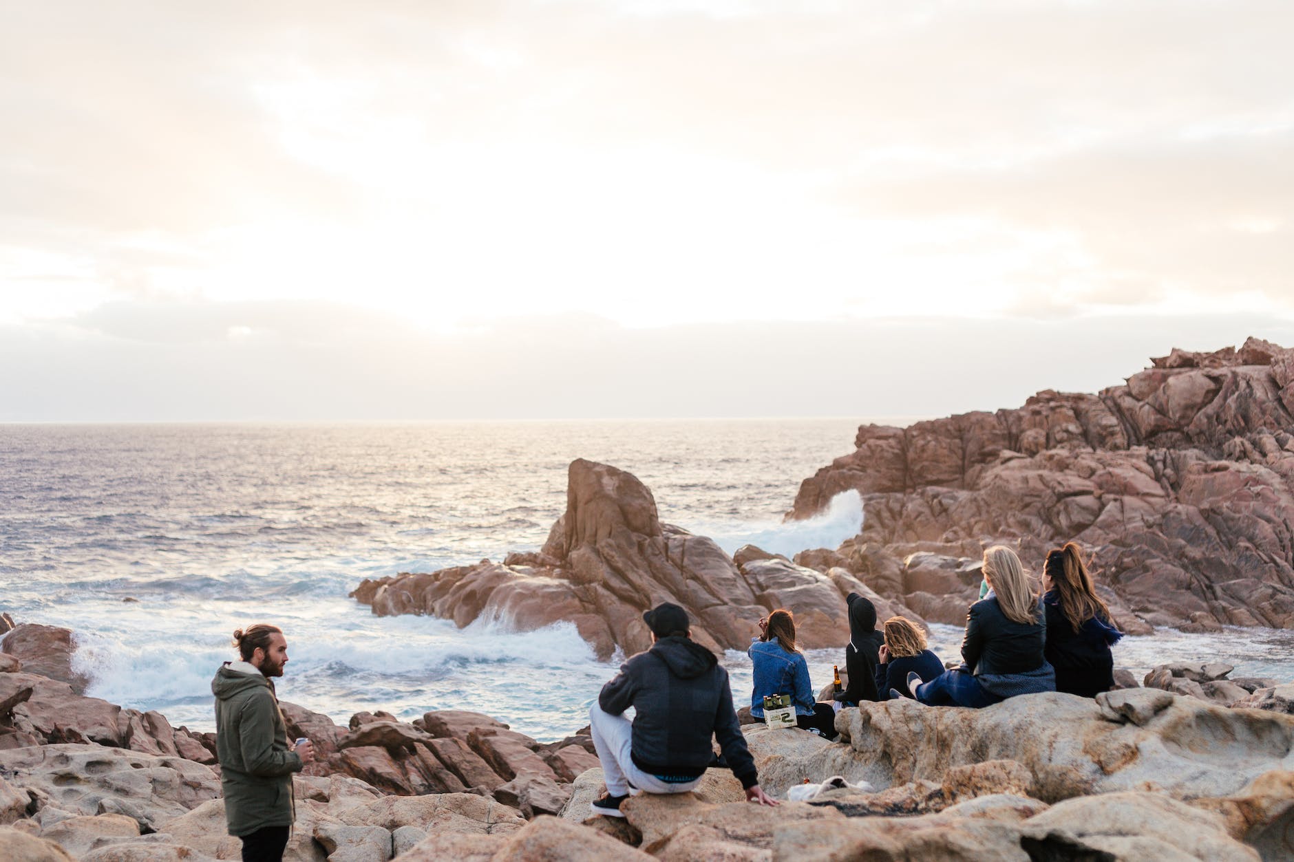 group of friends resting on rocky coast
