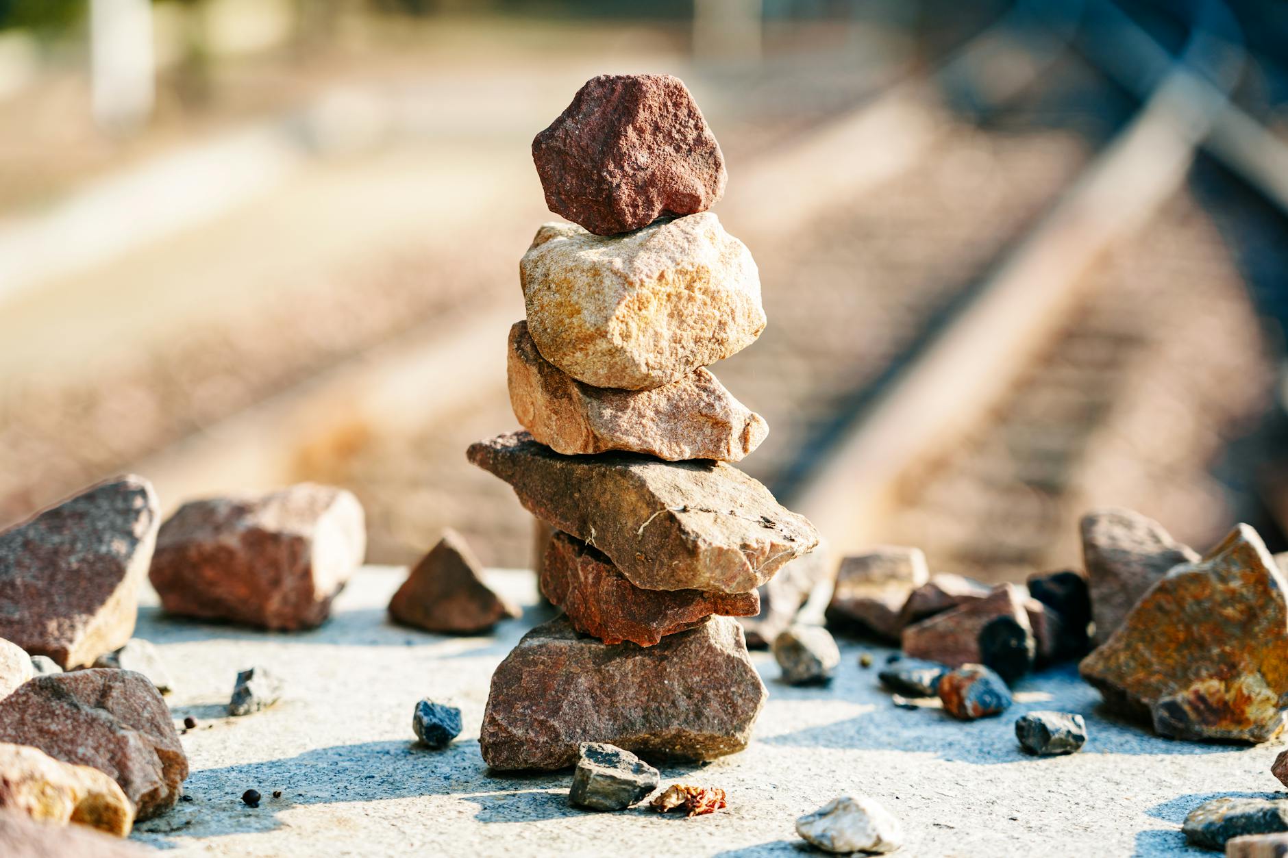 balanced rock stack near railway tracks outdoors